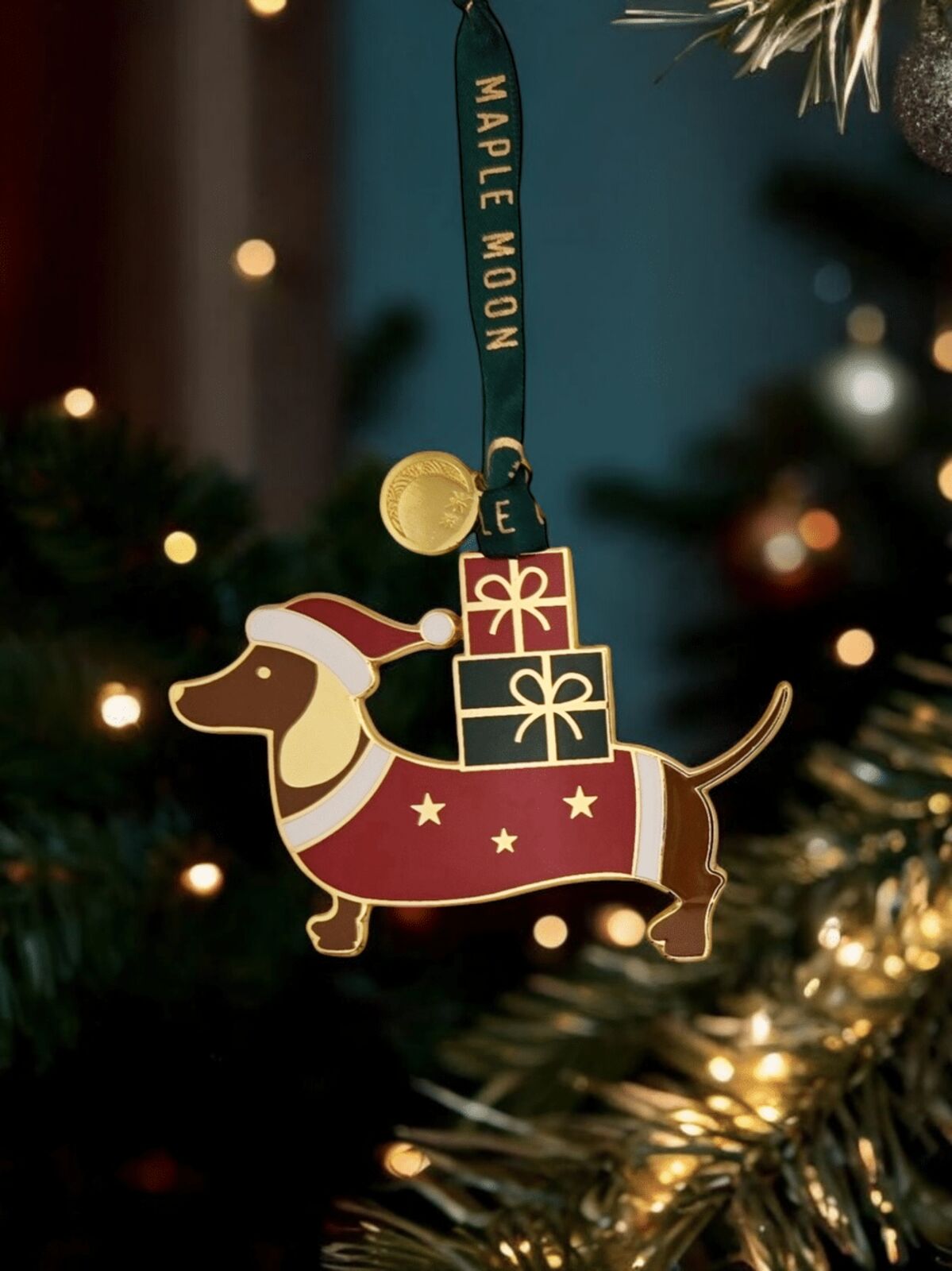 Christmas ornament of a dachshund with presents on a tree