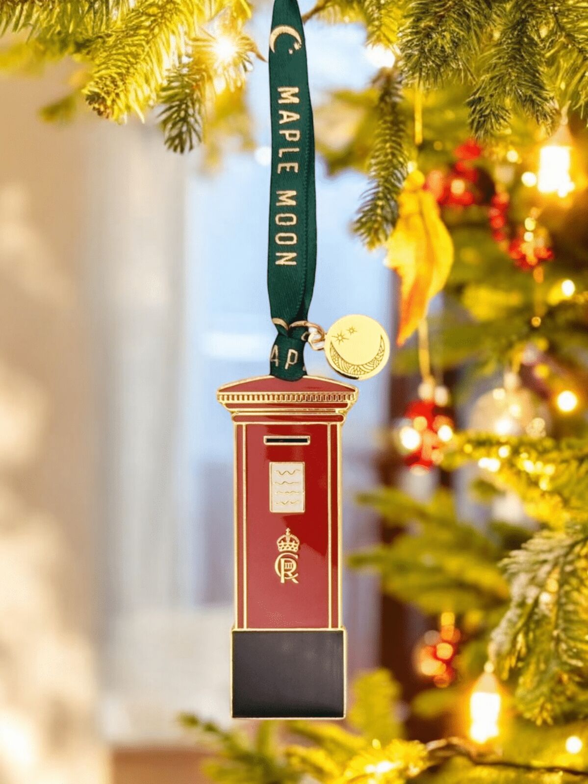 Decorative ornament resembling a mailbox on a Christmas tree with 'Maple Moon' branding.