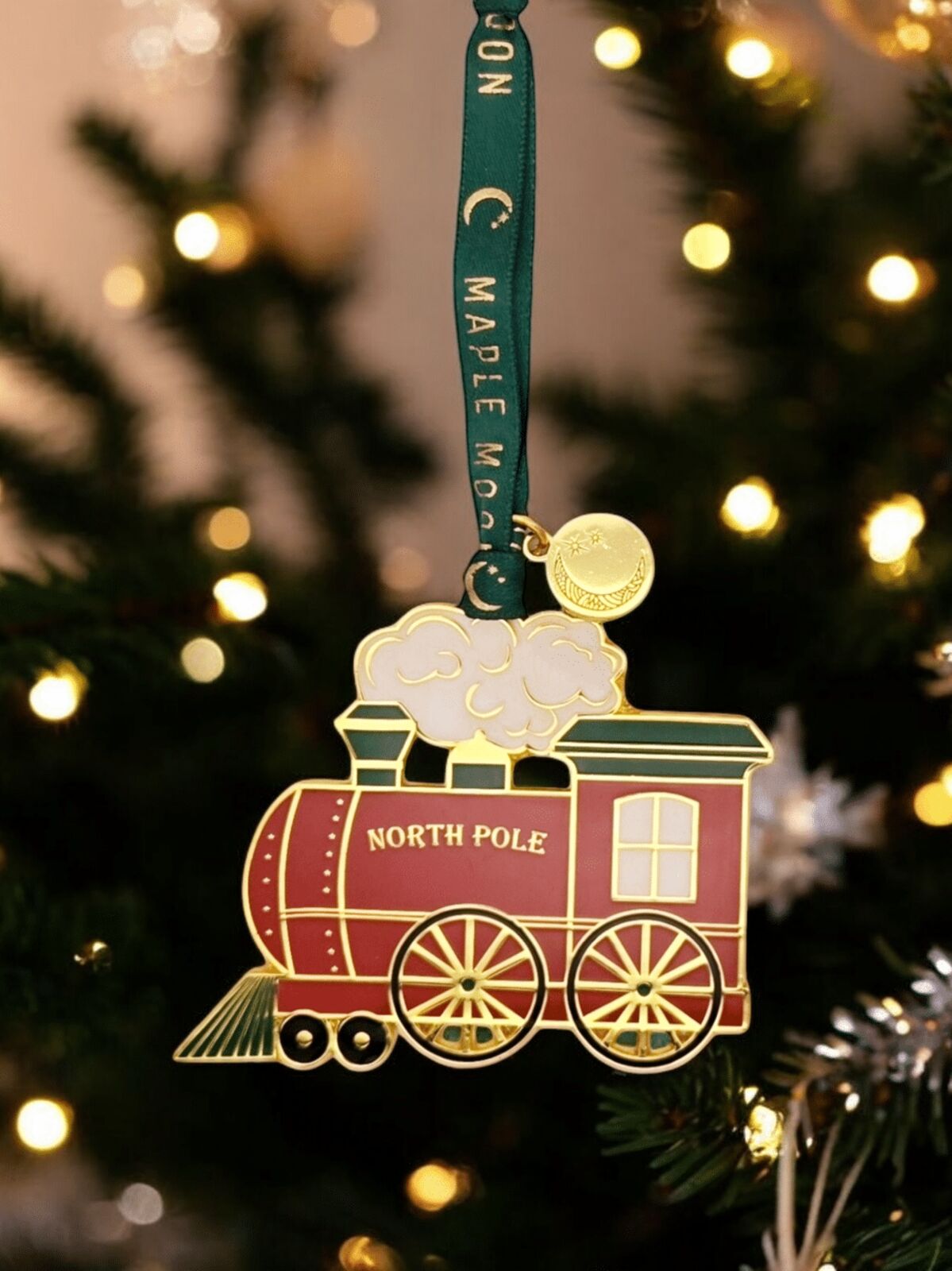 Decorative train ornament with 'North Pole' text on a Christmas tree.