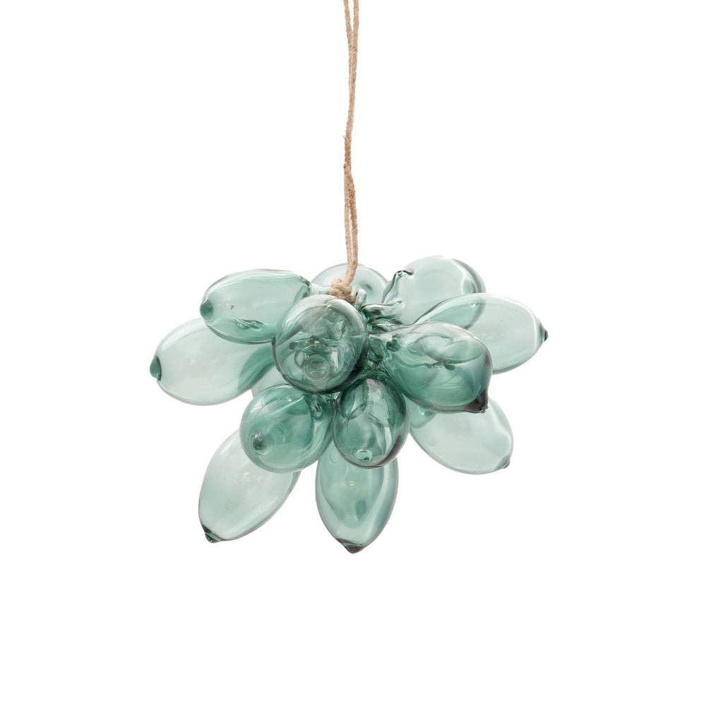 A handmade glass flower ornament in a translucent mint green color, suspended by a natural jute twine string against a solid white background.