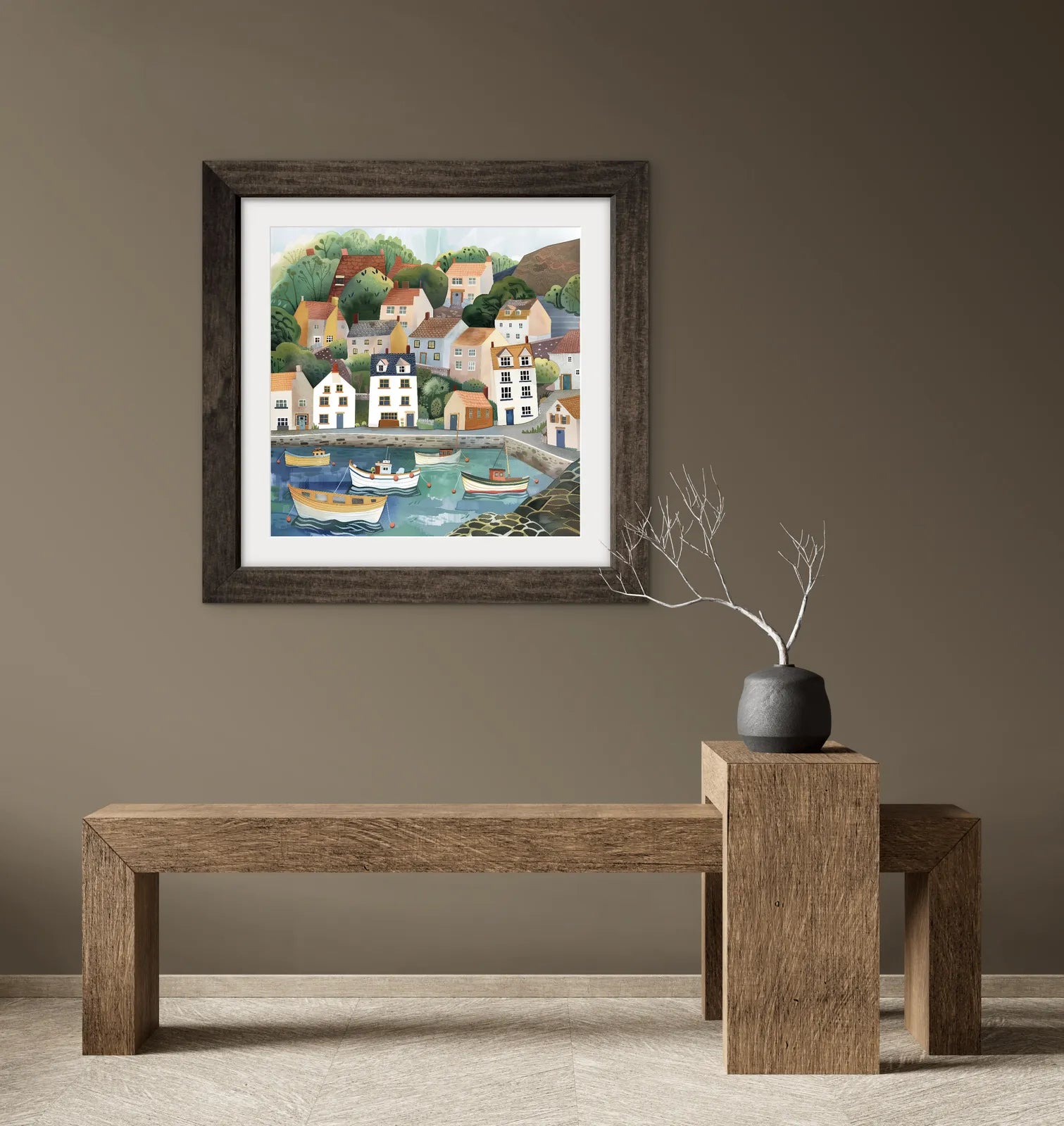 Framed artwork of a coastal scene on a wall above a wooden bench.