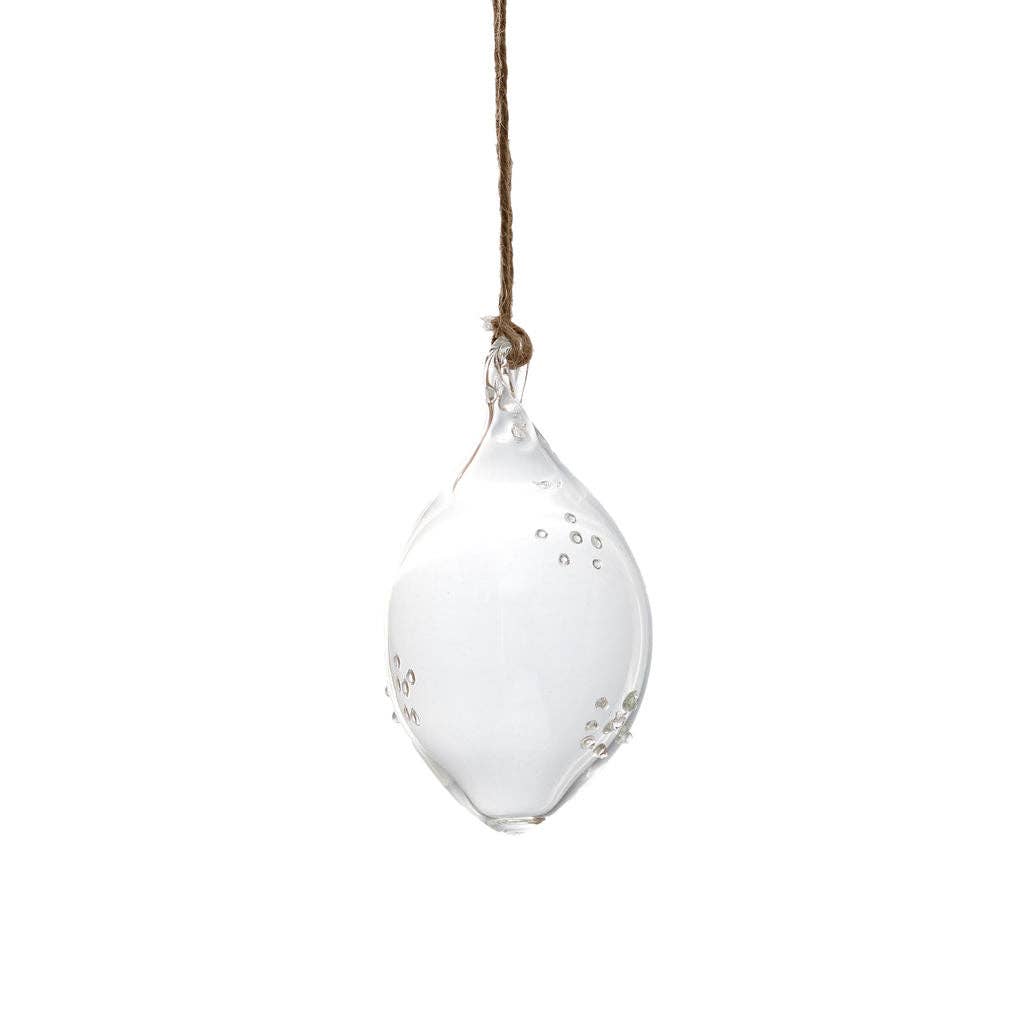 A clear glass teardrop-shaped hanging ornament with small metallic silver dots and a brown hanging string, shown against a solid white background.
