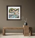 Framed artwork of a coastal scene on a wall above a wooden bench.